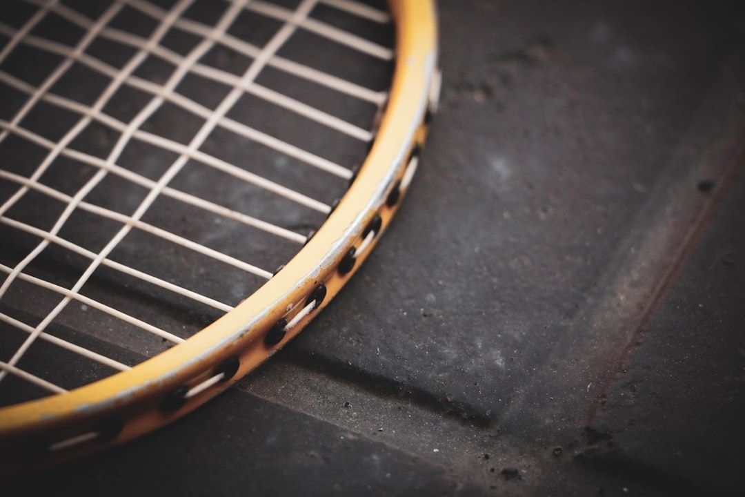 Närbild av ett slitet tennisracket med tätt strängmönster