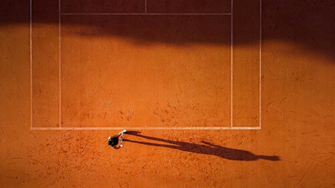 Tennisspelare tar en paus på den solbelysta grusbanan